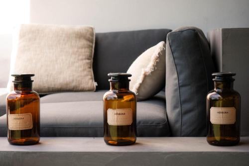 three bottles on a table in front of a couch at Arty Provence, vue, calme et piscine chauffée dans les Alpilles proche St-Rémy-de-Provence in Saint-Étienne-du-Grès