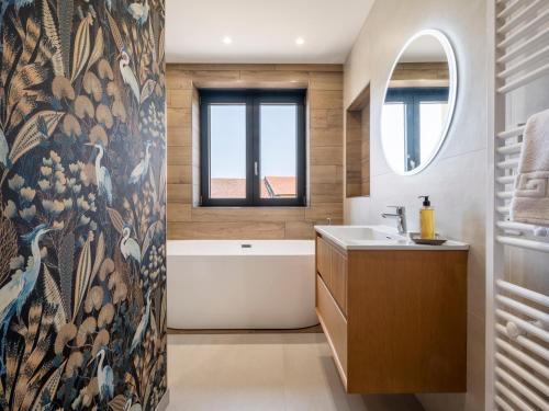 a bathroom with a tub and a sink and a window at La Ferme d'Estelle in Vulmont