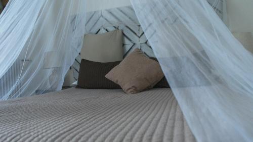 a bed with a mosquito net on it with pillows at B&B 7 Rooms in Pisa