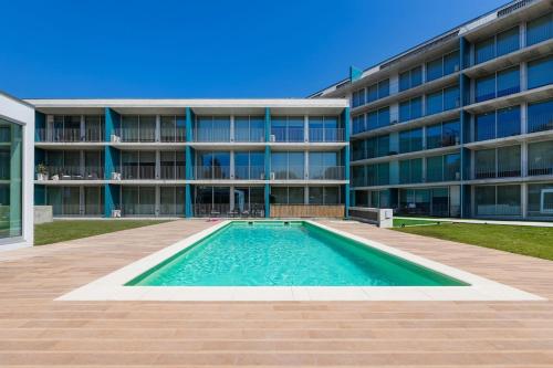 a swimming pool in front of a building at Olivia Maresia Homestay in Espinho