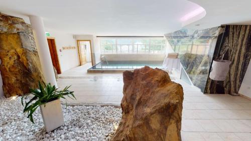 a large room with a pool and a large rock at Wellness Aparthotel Panorama Alpin - Ferienwohnungen Jerzens im Pitztal in Jerzens