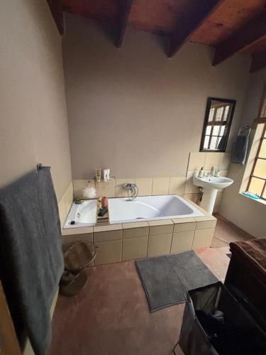 a large bathroom with a tub and a sink at Kudu's Corner in Marloth Park