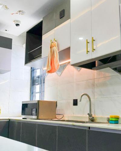 una cucina con mobili bianchi e un lavandino di 4 bed duplex in prime location a Ibadan