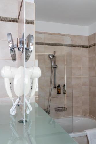 a bathroom with a shower and a toilet and a tub at Hotel Piramida in Maribor