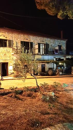a stone building with a tree in front of it at Skardamoula's Studios n Apartments in Kardamili