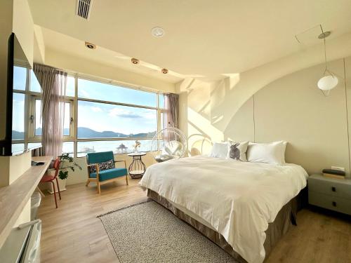 a bedroom with a large bed and a large window at 日月慢遊 in Yuchi