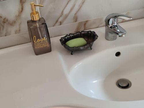 a bathroom sink with a soap in a basket on it at Casa TERESINA in Ardenno