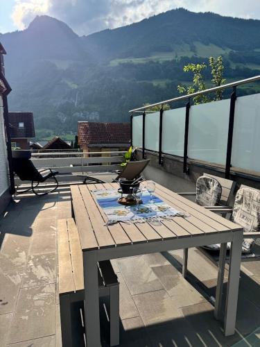 a wooden table on a balcony with a laptop on it at Bijou Lungern N 1 in Lungern