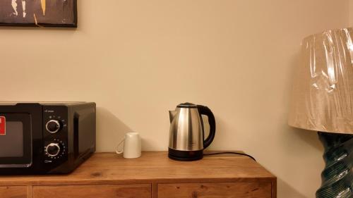 - une cafetière installée au-dessus d'un four micro-ondes dans l'établissement 3 Serenity U Private Residence, à Khobar