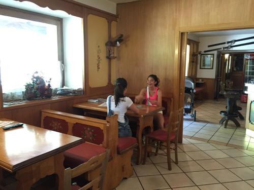 two women sitting at a table in a restaurant at Hotel Tosa in Madonna di Campiglio