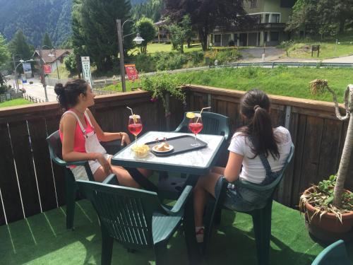 two women sitting at a table with wine glasses at Hotel Tosa in Madonna di Campiglio