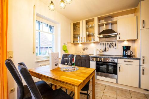 a kitchen with a wooden table with chairs around it at Südblick 1Whg 4 in Werdum
