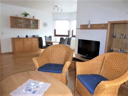 a living room with a table and chairs and a television at Baltique Fewo 1 in Glowe
