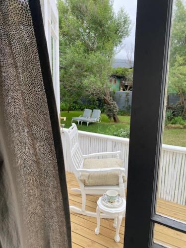 a porch with a chair and a table with a coffee table at Die Kuierhuis - style in the heart of Stanford in Stanford