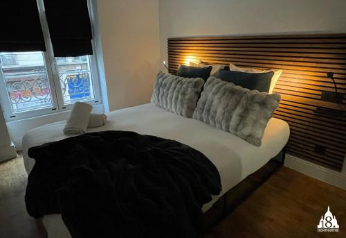a bedroom with a large white bed with pillows at 18 Montmartre in Paris