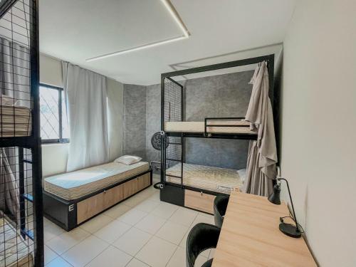 Una habitación compartida con dos literas y un escritorio. en Belô Hostel, en Belo Horizonte