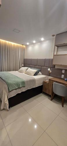 a bedroom with a large bed and a table at Belém COP30 Apartment in Belém