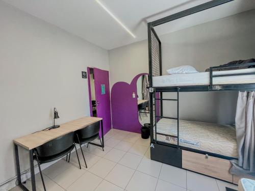 a room with two bunk beds and a desk at Belô Hostel in Belo Horizonte