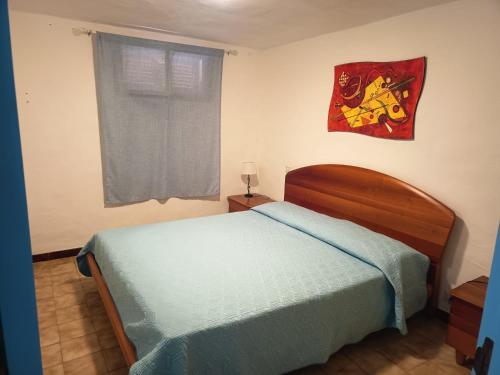 Un dormitorio con una cama y un cuadro en la pared. en I Fenicotteri Baia Caddinas, en Golfo Aranci