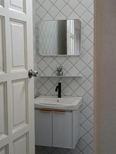 a white bathroom with a sink and a mirror at Lu&Lu Rooms & Homestay in Dungun