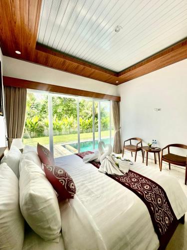 a large bed in a room with a large window at Aldi's House Villa in Bedahulu