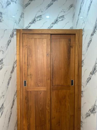 a wooden door in a room with marble walls at Aldi's House Villa in Bedahulu