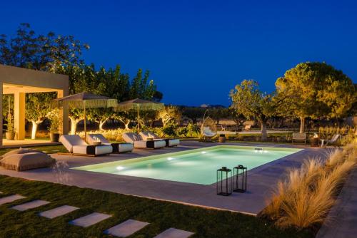 a swimming pool in a yard at night at The Attican Villa & Estate in Anavissos