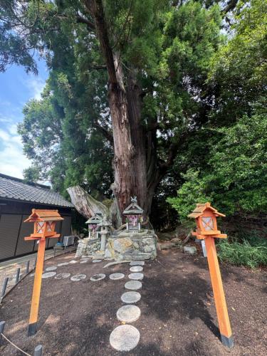 a garden with two orange posts and a tree at Osugi-ya 大杉屋 in Wazuka