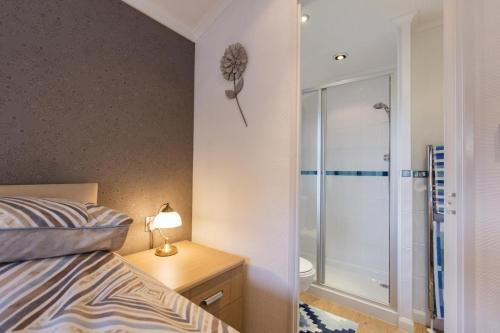 Un dormitorio con una cama y una ducha a ras de suelo. en The South Vista, en Swarland