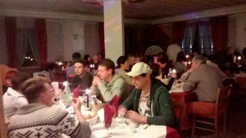 a group of people sitting at tables in a restaurant at Hotel Tosa in Madonna di Campiglio