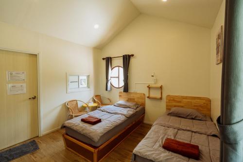 a bedroom with two beds and a table at นารา พรีเมียม รีสอร์ท @ชัยนาท in Chai Nat