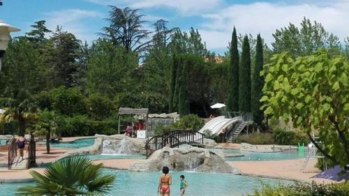 a water park with a slide and people in the water at Les Platanes in Nyons