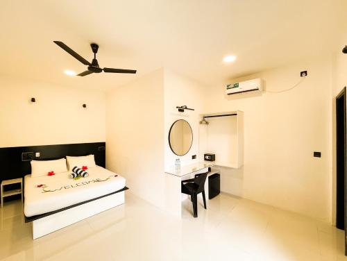 a bedroom with a bed and a mirror and a desk at Tropical Escape Inn in Hangnaameedhoo
