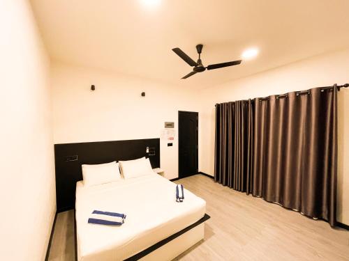 a bedroom with a bed and a ceiling fan at Tropical Escape Inn in Hangnaameedhoo