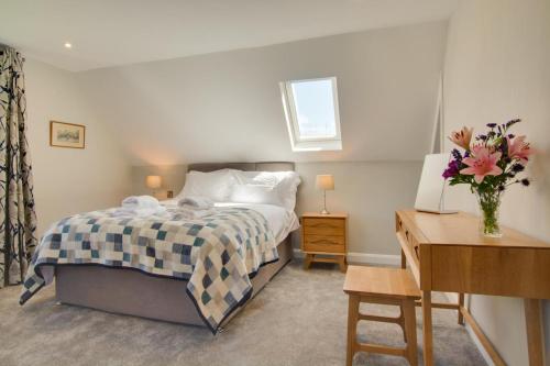 ein Schlafzimmer mit einem Bett, einem Tisch und einem Schreibtisch in der Unterkunft Peaty Cottage in Panxworth