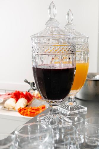 a glass vase with a drink in it on a table at Lym Flat Hotel in Uberlândia
