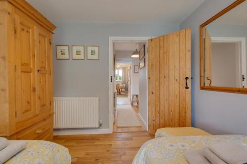 a bedroom with two beds and a mirror and a hallway at The Stables in Thurgarton