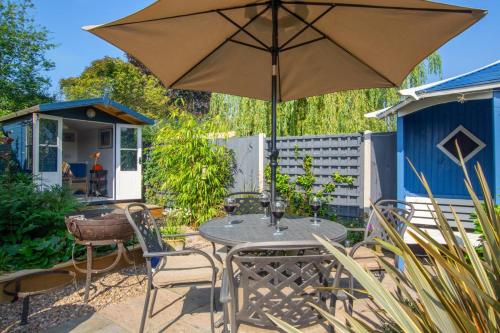 a patio with a table and an umbrella at The Stables in Thurgarton