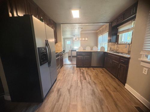 a large kitchen with wooden floors and a refrigerator at Lahoma Bungalow in Norman