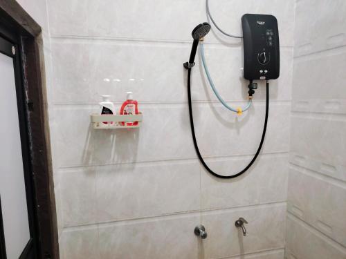 a shower with a phone on the wall in a bathroom at Roomstay Kak Ton DELUXE ROOM in Kuala Terengganu