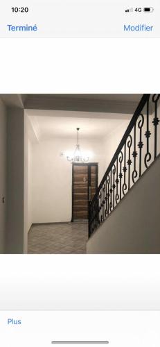 a room with a staircase with a chandelier at 3 appartements Niveau de villa avec garage 