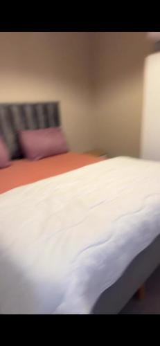 a close up of a white bed in a room at 3 appartements Niveau de villa avec garage 