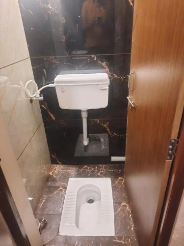 a small bathroom with a toilet in a stall at Raj Laxmi Homestay in Ujjain