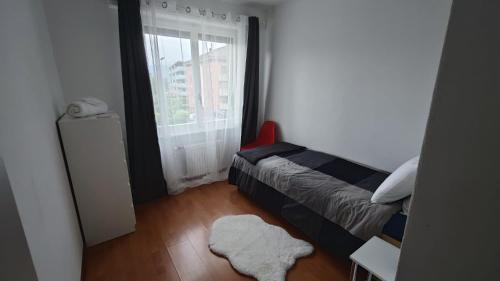 a small bedroom with a bed and a window at Coucouning Appartement ou chambres privées espaces communs à partager in Monthey