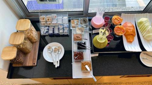 a table with food on it with plates and spoons at Lym Flat Hotel in Uberlândia