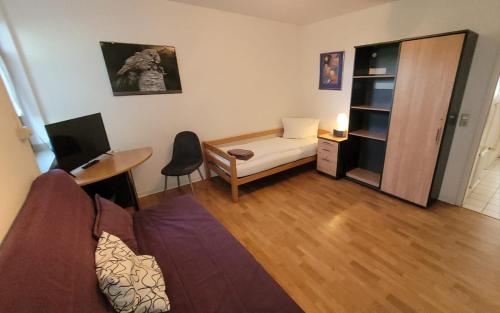 a living room with a couch and a desk at Monteurs-Apartment Graf Häseler in Lünen