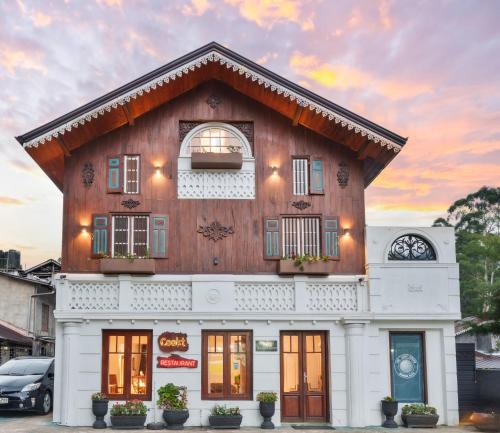 a large white building with a wooden roof at The Golf Green City Bungalow in Nuwara Eliya