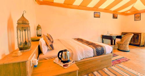 a bedroom with a bed and a desk with a desk at The Desert Gateway Resort in Jaisalmer