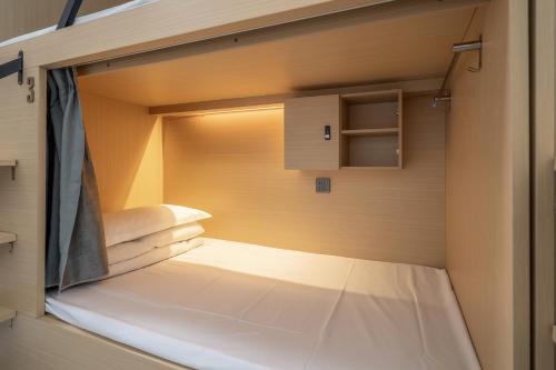 a small room with a bed inside of it at Passerby hostel samui in Amphoe Koh Samui