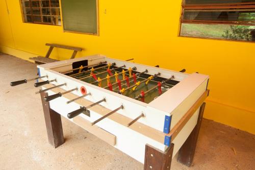 a large foosball table in a yellow room at Chácara with pool and trails in the Cerrado biome in São Carlos